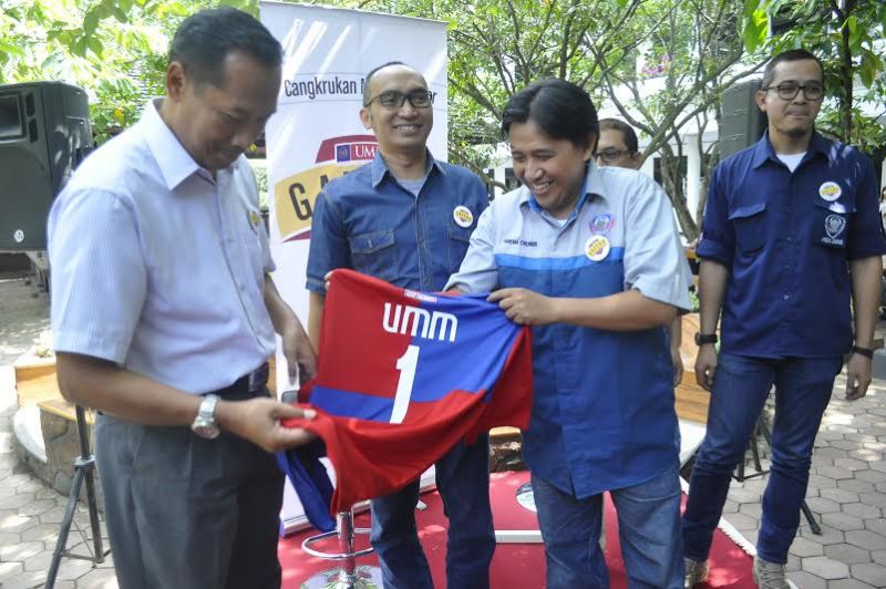 Manajer Media Officer Arema, Sudarmaji, memberikan jersey bernomor punggung satu dengan nama UMM pada