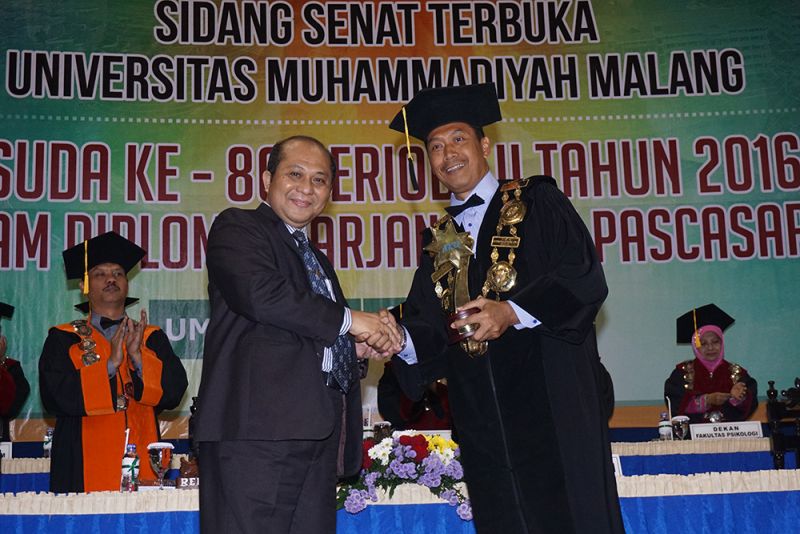 Rektor UMM, Fauzan, saat menerima piala AKU dari Koordinator Kopertis VII Jawa Timur, Prof Suprapto.