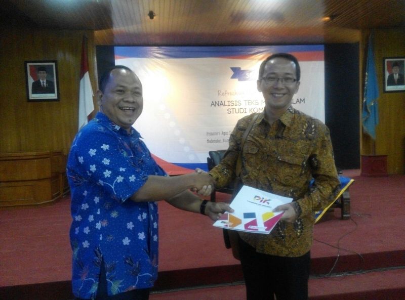 The Chief of the Department of Communication Studies, Sugeng Winarno, MA giving the souvenir to Agus