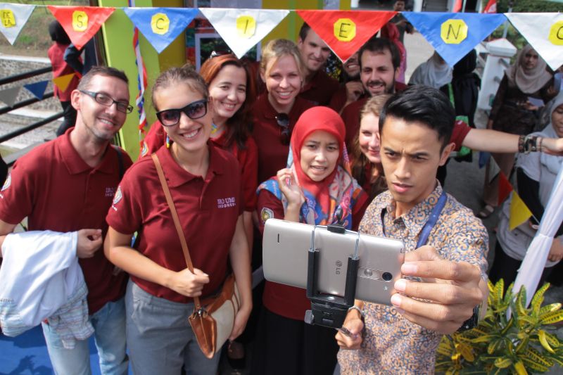 Pengujung Festival Sains berfoto selfie bersama sejumlah mahasiswa asing.   عقد المكتب