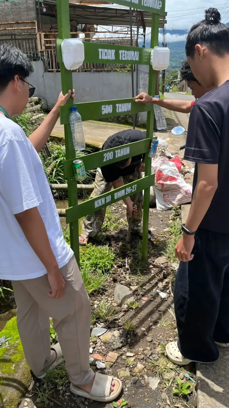 Mahasiswa KKN Kelompok 10 UMM, Pasang Papan Edukasi “Waktu Urai Sampah”